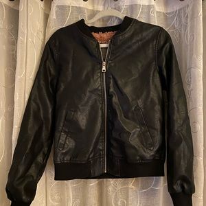 Black leather jacket with pockets, pink fluffy material in the inside.